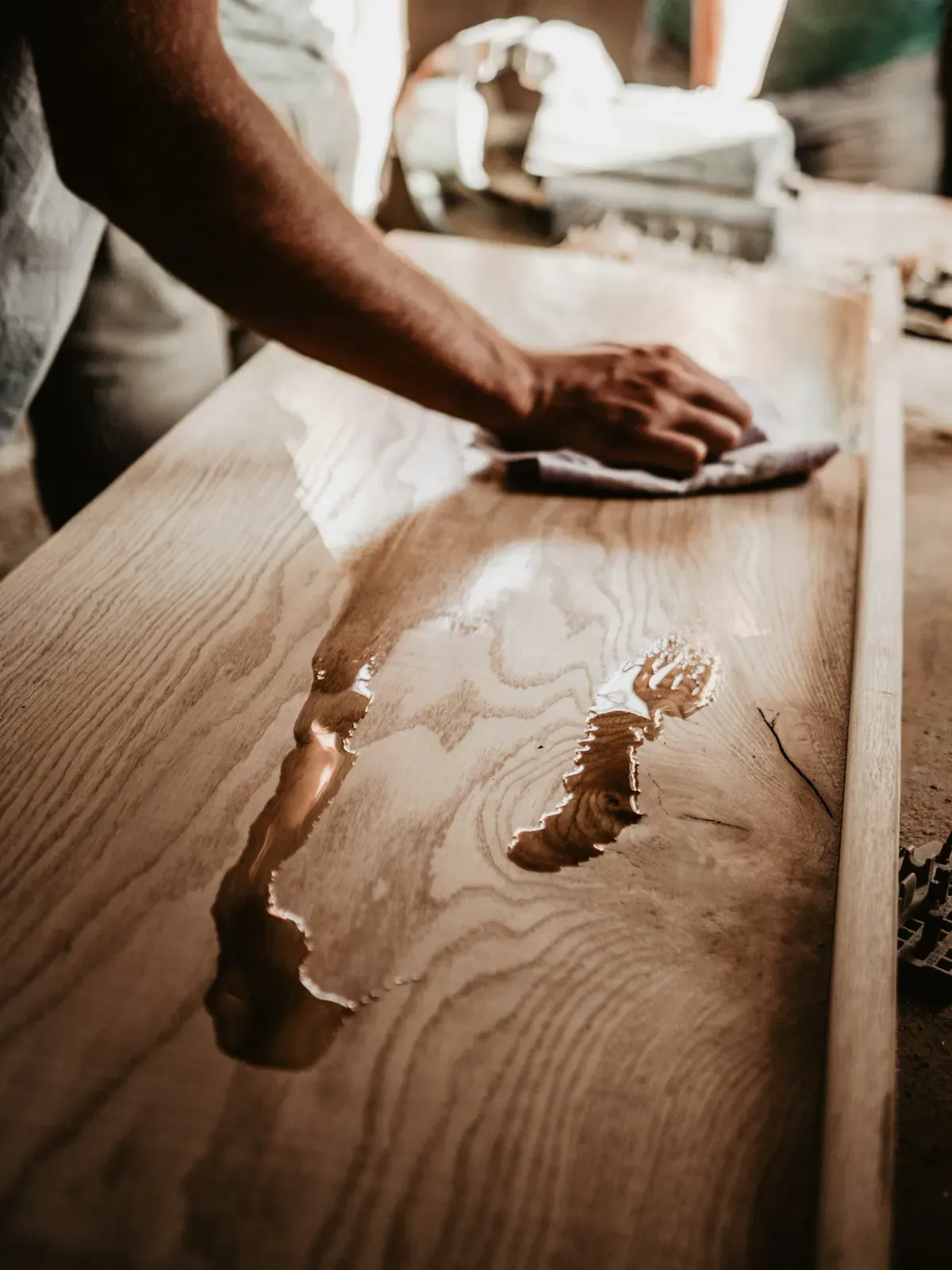 Person demonstrating how to clean wood furniture with a soft cloth.